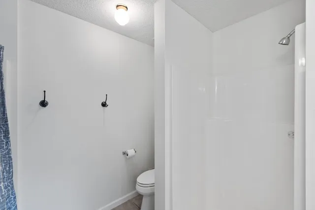 a white toilet sitting next to a shower