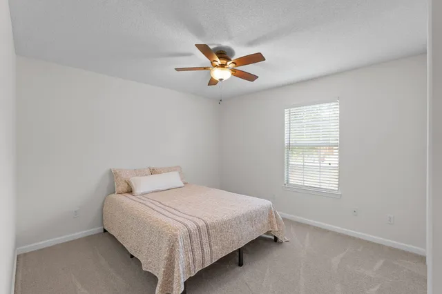 a bedroom with a bed and a ceiling fan