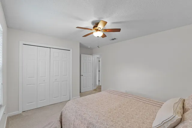 a bedroom with a bed and a chandelier fan