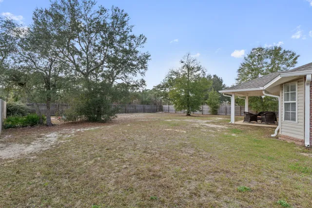 a view of a house with backyard and a tree