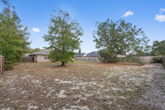a view of a house with a yard and a tree