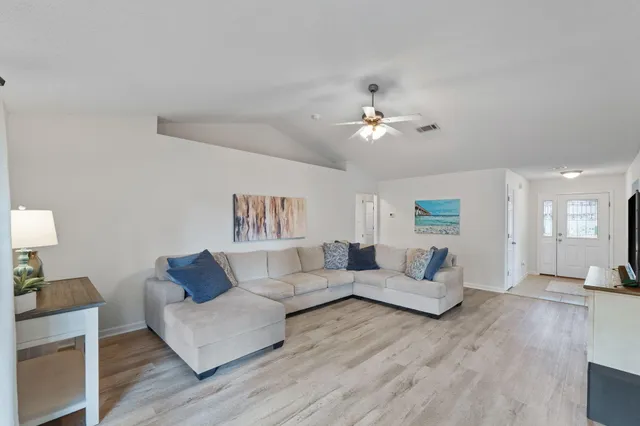 a living room with furniture and a wooden floor
