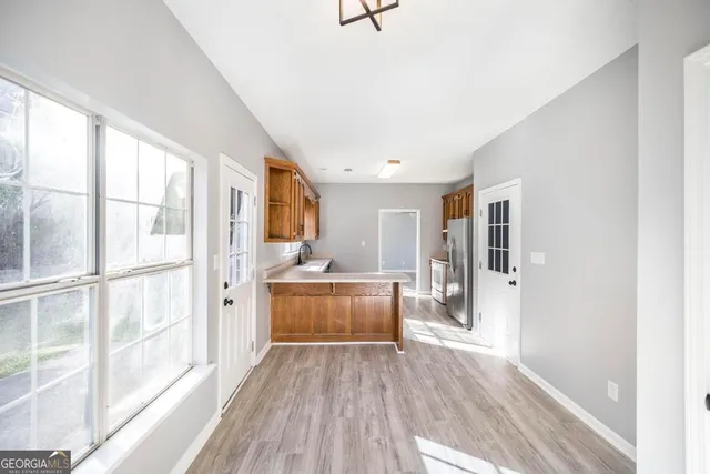a kitchen with a refrigerator and wooden floor