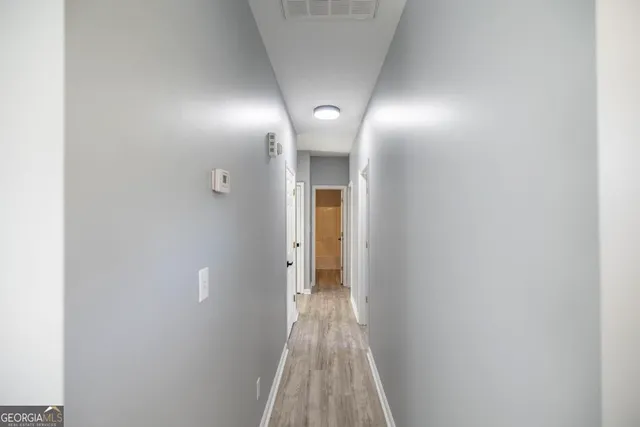 a view of a hallway with wooden floor