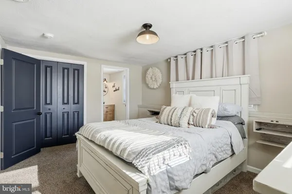 a bedroom with a large bed and a chandelier