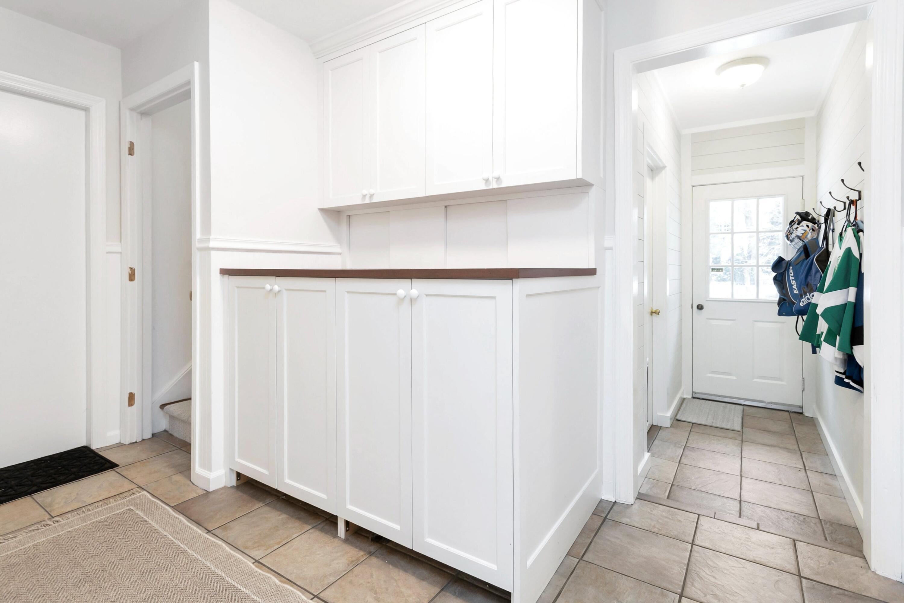 2 Red Barn Road Darien, CT 06820 - Photo 19 of 38 a view of a kitchen with white cabinets and a hallway