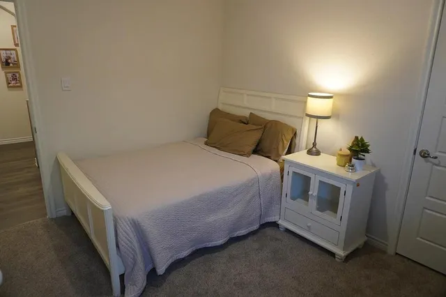 a bed sitting in a room next to a lamp