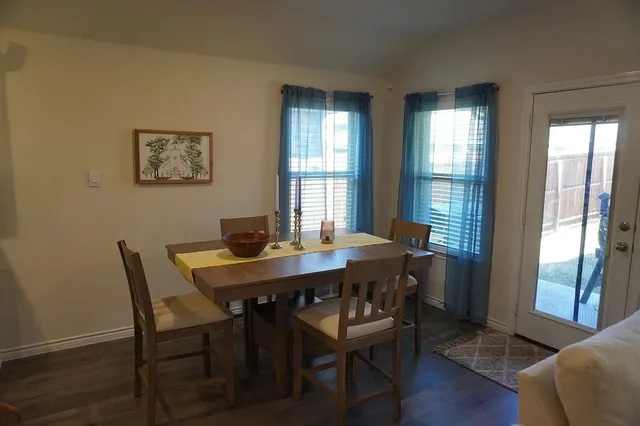 a view of a dining room with furniture wooden floor and a potted plant