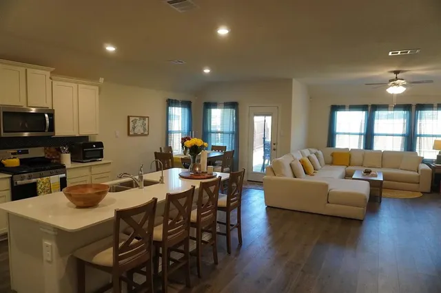 a living room with furniture and a wooden floor