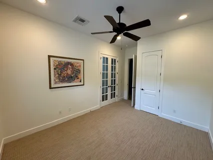 a view of a livingroom with a ceiling fan & windows