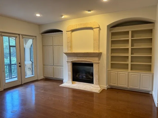 an empty room with a fireplace wooden floor and windows