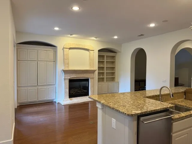 a kitchen with sink wooden floor and fireplace