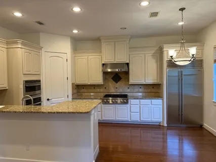 a kitchen with stainless steel appliances granite countertop a sink and a refrigerator