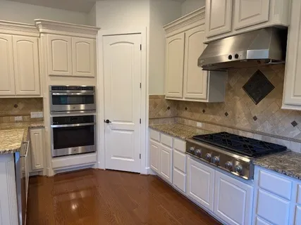 a kitchen with granite countertop a stove and a microwave