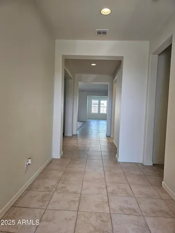 a view of a hallway with wooden floor and a bathroom