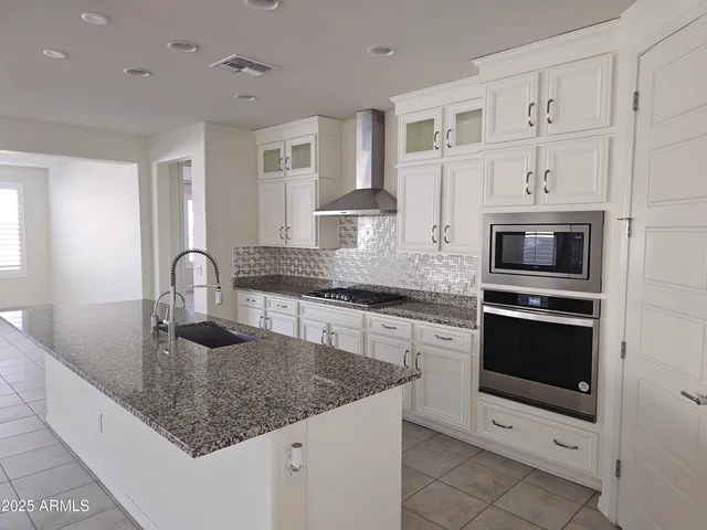 a kitchen with granite countertop a sink stainless steel appliances and cabinets
