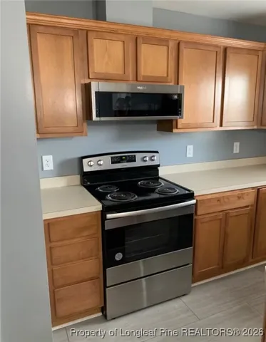a kitchen with stainless steel appliances granite countertop a stove microwave and cabinets