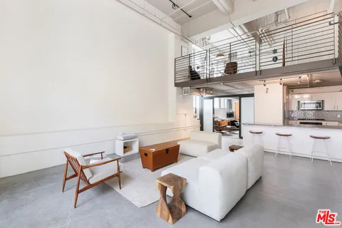 a living room with furniture and a kitchen view