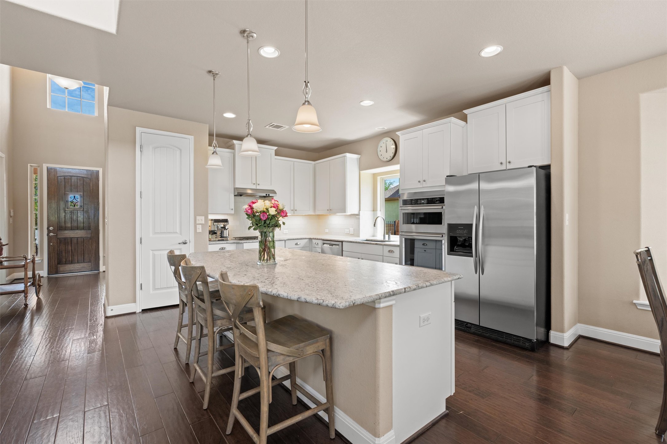 7716 Aria Loop Austin, TX 78736 - Photo 15 of 39 A gourmet kitchen awaits with a spacious island, gleaming stainless steel appliances, and rich hardwood flooring.