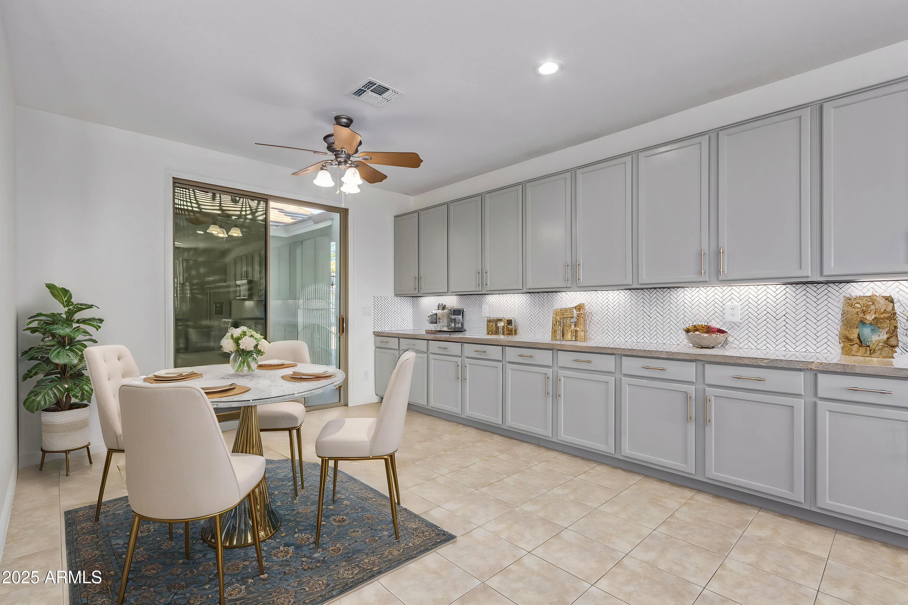 13635 West Calavar Road Surprise, AZ 85379 - Photo 30 of 76 a kitchen with a dining table chairs and white cabinets