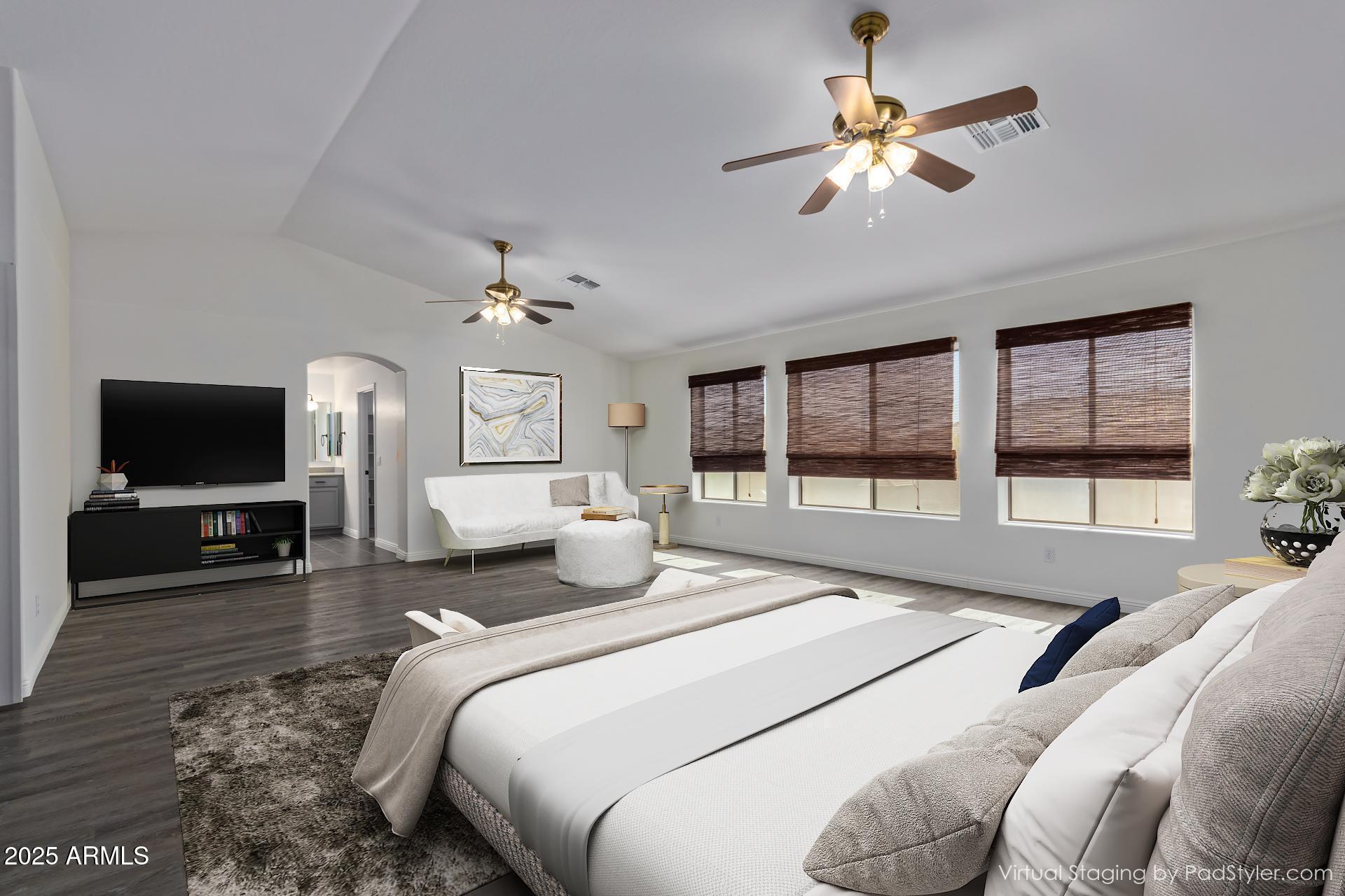 13635 West Calavar Road Surprise, AZ 85379 - Photo 40 of 76 a bedroom with a large bed a flat tv screen and a chandelier