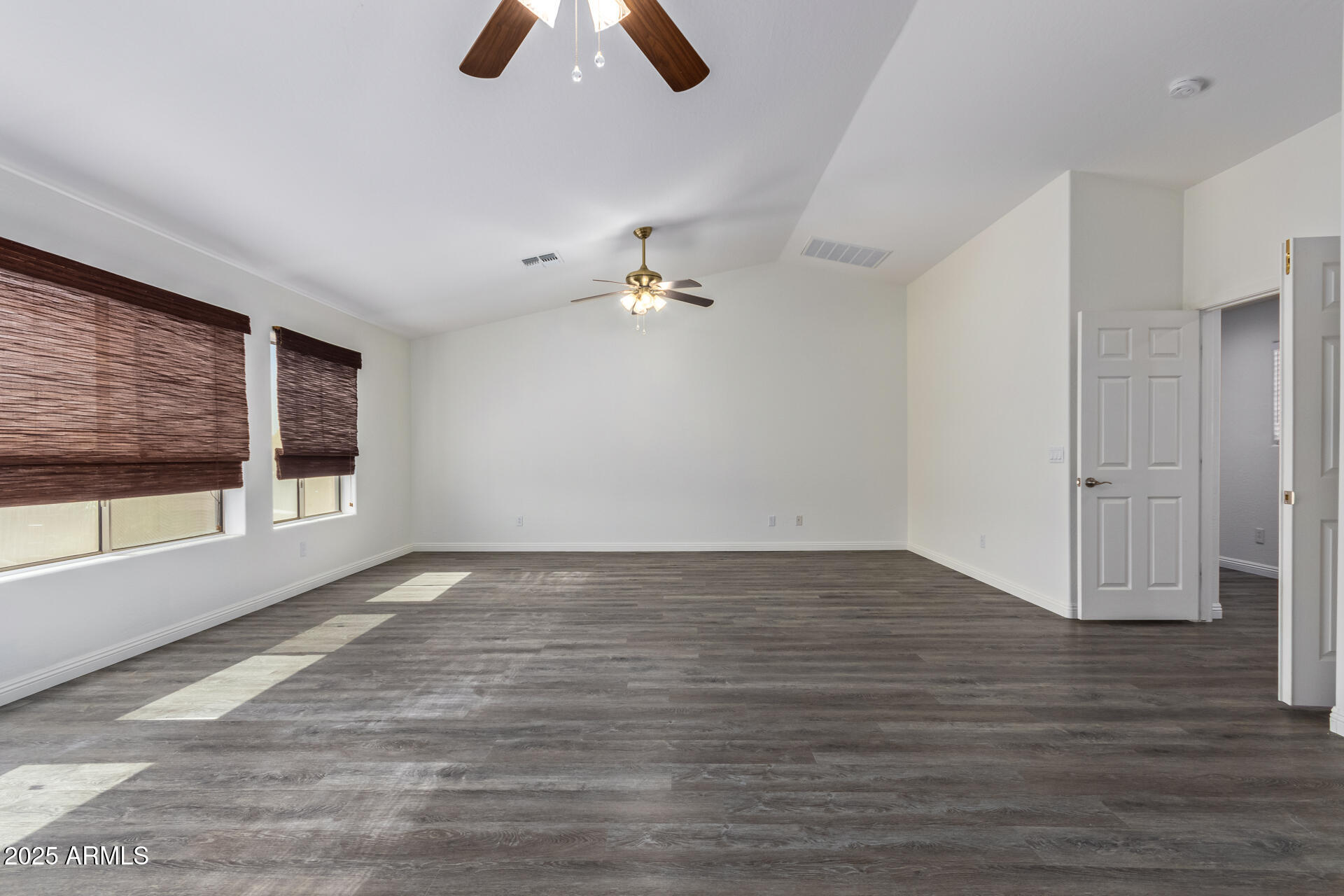 13635 West Calavar Road Surprise, AZ 85379 - Photo 45 of 76 a view of an empty room with wooden floor and a window
