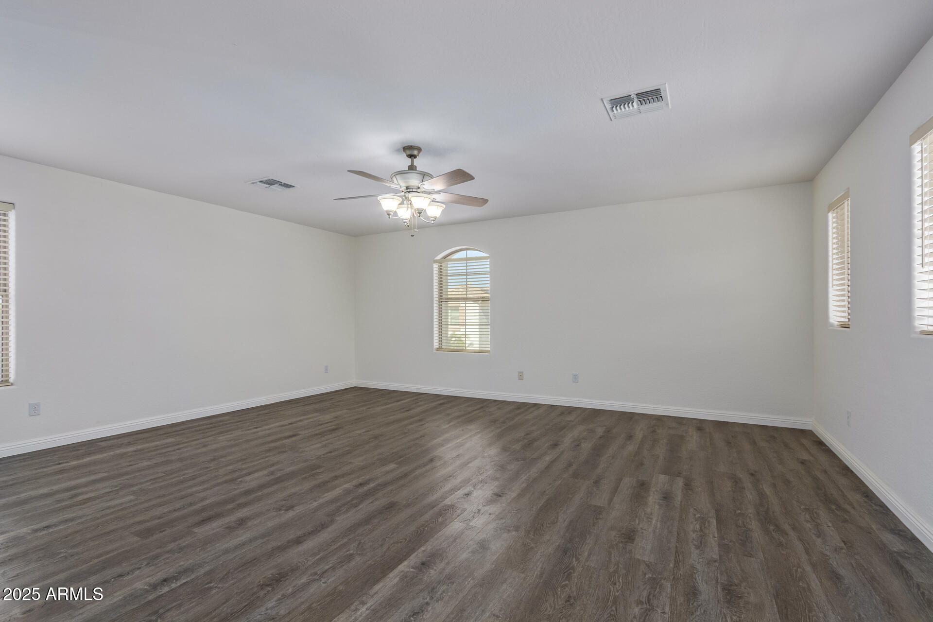 13635 West Calavar Road Surprise, AZ 85379 - Photo 52 of 76 a view of an empty room with wooden floor and a window