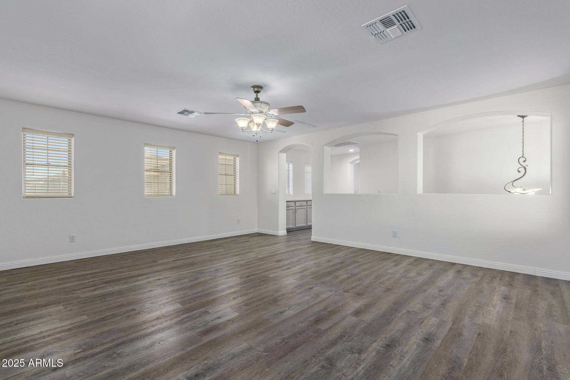 13635 West Calavar Road Surprise, AZ 85379 - Photo 54 of 76 a view of an empty room with wooden floor and a window