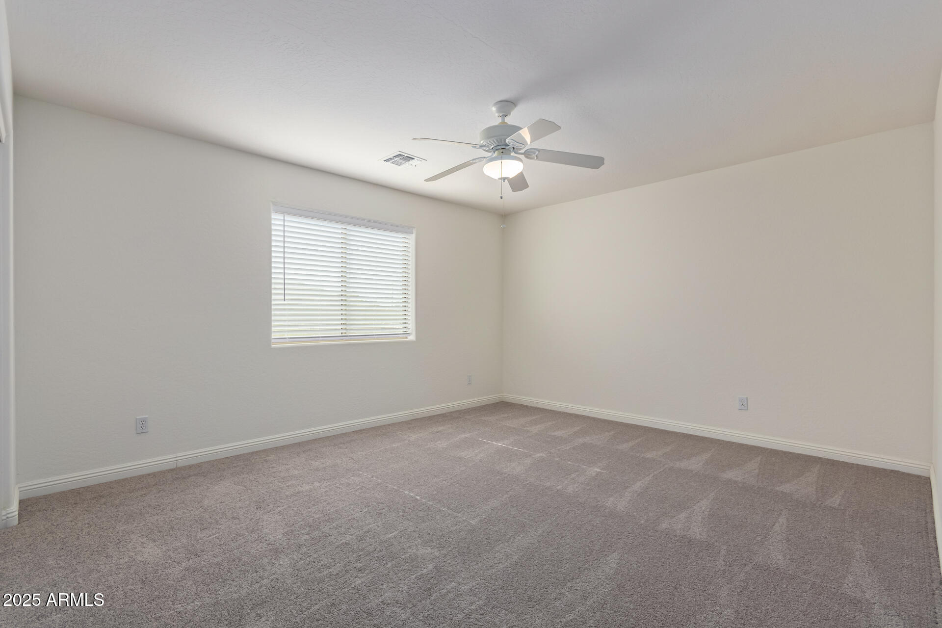 13635 West Calavar Road Surprise, AZ 85379 - Photo 61 of 76 an empty room with a window and ceiling fan