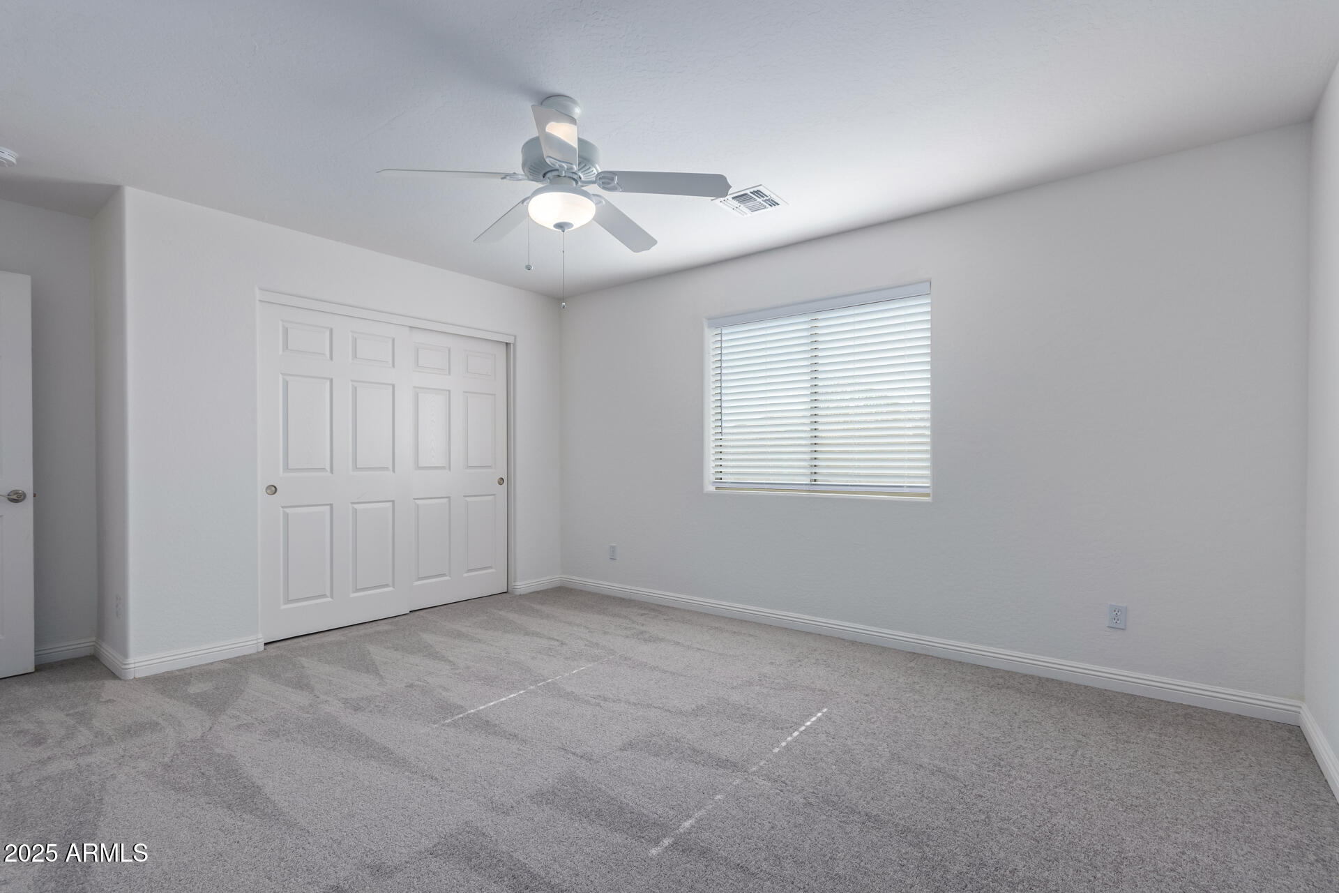 13635 West Calavar Road Surprise, AZ 85379 - Photo 62 of 76 an empty room with windows and fan