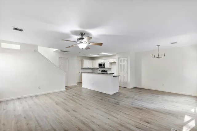 a view of a kitchen with wooden floor and a ceiling fan