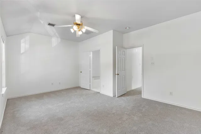 a view of an empty room with a chandelier fan