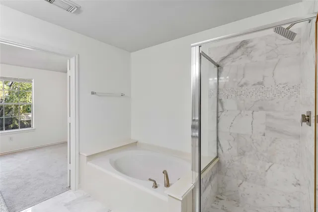 a bathroom with a tub shower and sink