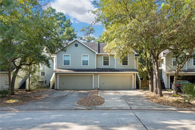 a view of a house with a yard and large tree