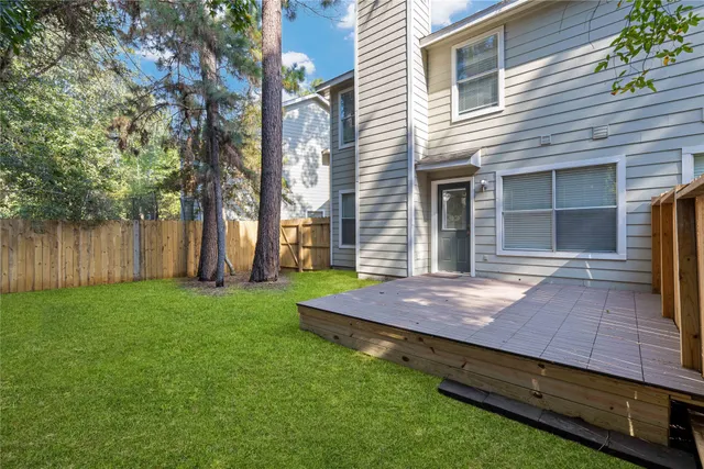 a view of backyard with wooden floor and fence