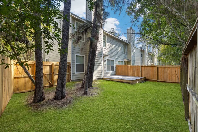 a view of backyard with a barn and a large tree