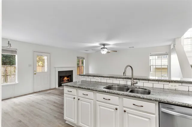 a kitchen with granite countertop a sink cabinets window and appliances