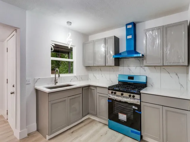 a kitchen with stainless steel appliances a sink stove and cabinets