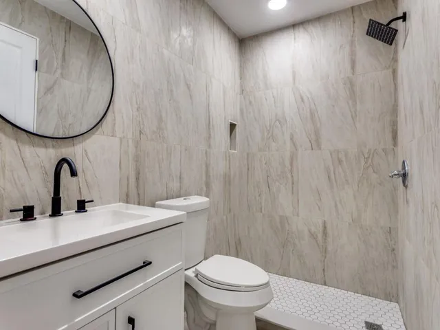 a bathroom with a sink a toilet and a mirror