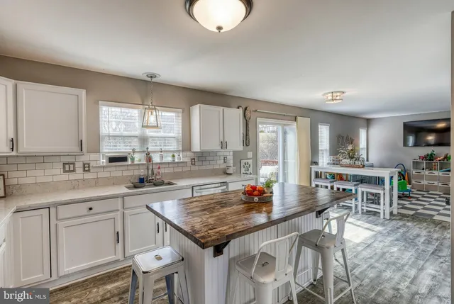 a kitchen with granite countertop a table chairs sink and cabinets