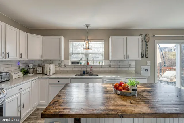 a kitchen with sink a stove and cabinets