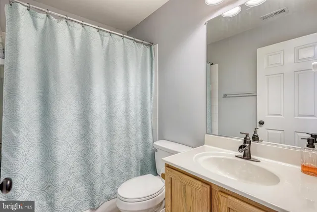a bathroom with a sink a toilet and shower curtain