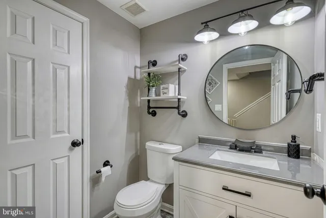 a bathroom with a toilet a sink and mirror