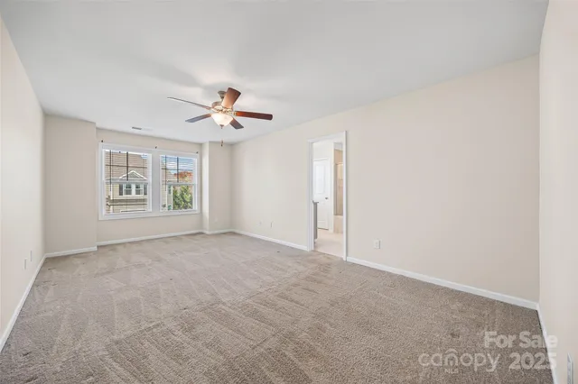 an empty room with windows and ceiling fan