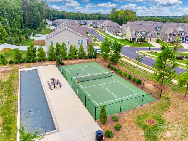 an aerial view of a tennis ground and a houses