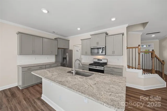 a kitchen with stainless steel appliances granite countertop a sink stove and refrigerator