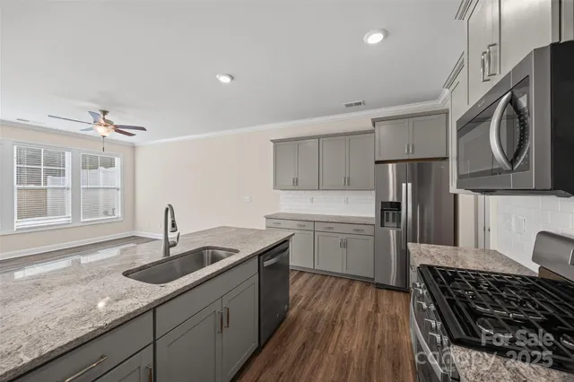 a kitchen with stainless steel appliances granite countertop a sink stove and refrigerator