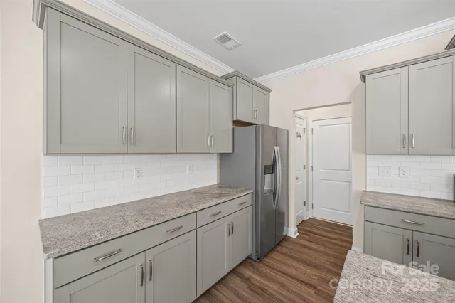 a kitchen with a sink a refrigerator and cabinets