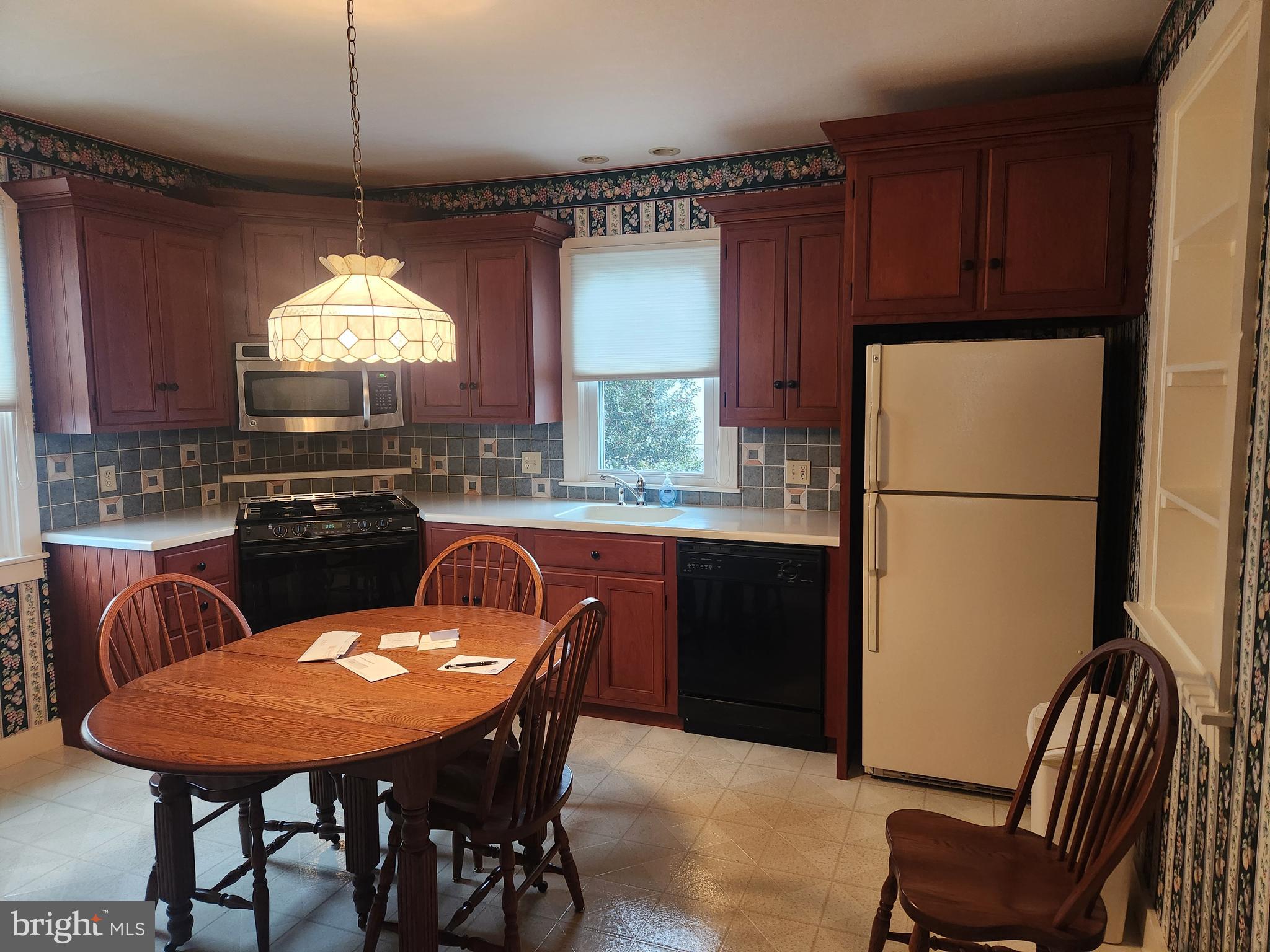 123 North 11th Street Akron, PA 17501 - Photo 14 of 43 a kitchen with a refrigerator a stove a sink and a dining table