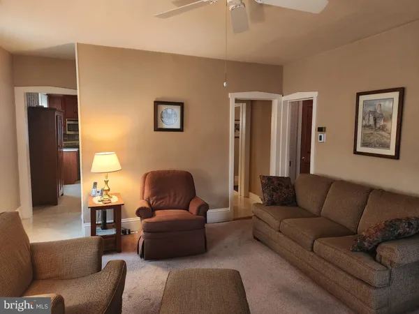 a living room with furniture and a ceiling fan